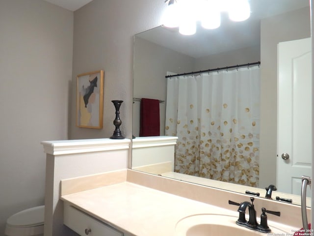 bathroom featuring toilet, vanity, and walk in shower