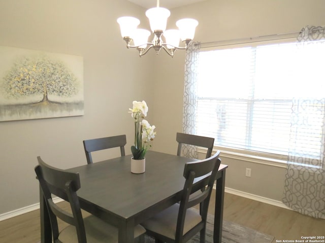 dining area with dark hardwood / wood-style floors and an inviting chandelier