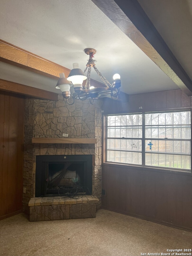 carpeted living room with beam ceiling, a fireplace, and wooden walls