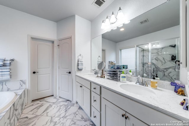 bathroom with vanity and shower with separate bathtub