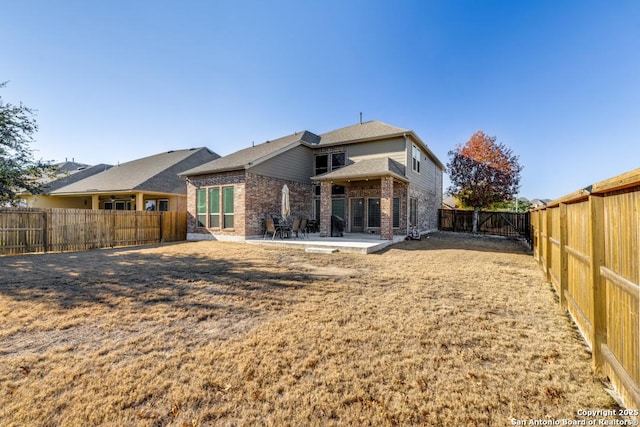 rear view of house featuring a patio and a lawn