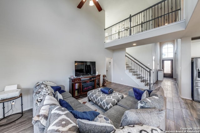 living room with a towering ceiling and ceiling fan