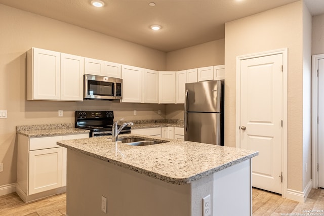 kitchen featuring white cabinetry, appliances with stainless steel finishes, and an island with sink