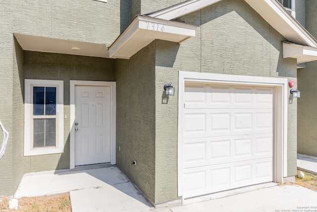 doorway to property with a garage