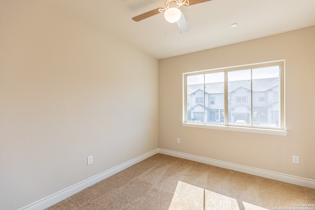 carpeted spare room featuring ceiling fan