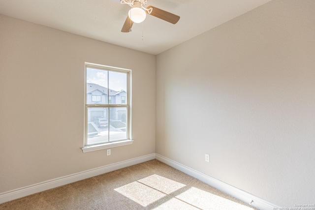 spare room with ceiling fan and light colored carpet