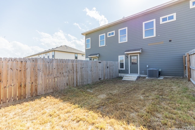 back of property with a lawn and central AC unit