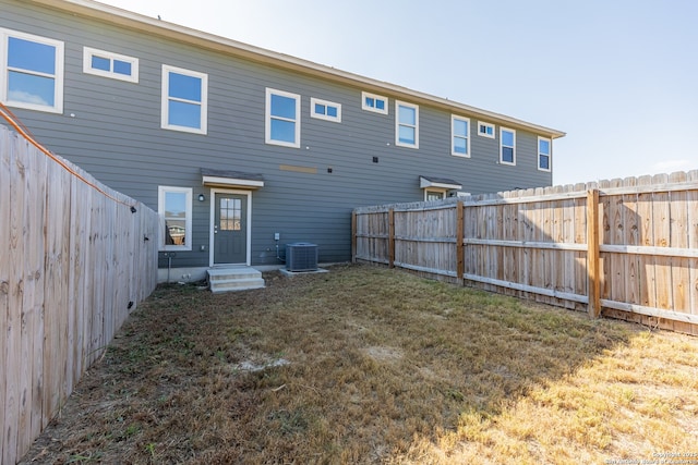 back of property featuring cooling unit and a yard