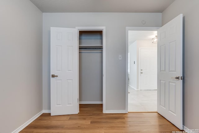 unfurnished bedroom with a closet and light hardwood / wood-style floors