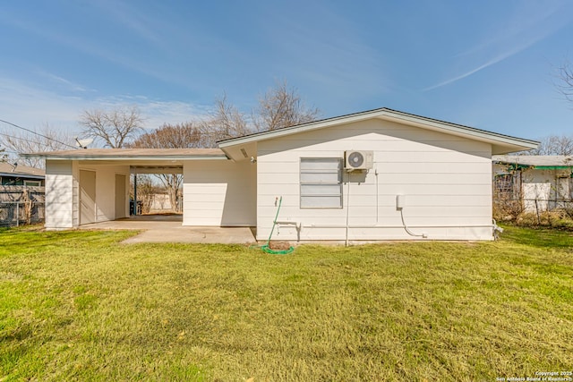 rear view of property with a carport and a yard