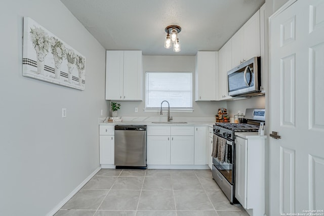 kitchen featuring light tile patterned floors, stainless steel appliances, white cabinets, and sink