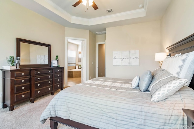 carpeted bedroom with ceiling fan, ensuite bathroom, ornamental molding, and a raised ceiling