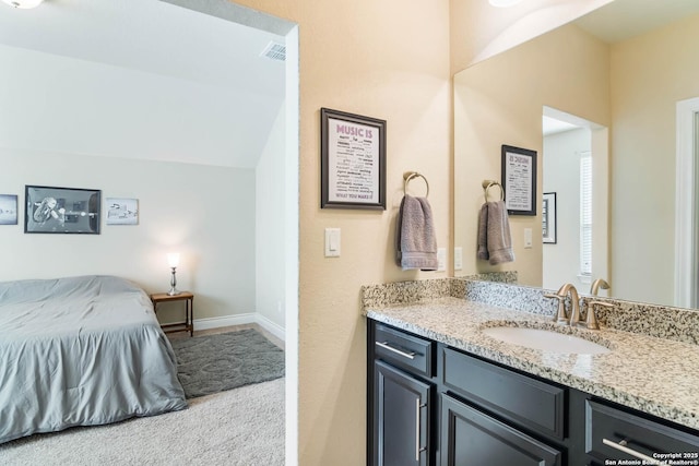 bathroom with lofted ceiling and vanity