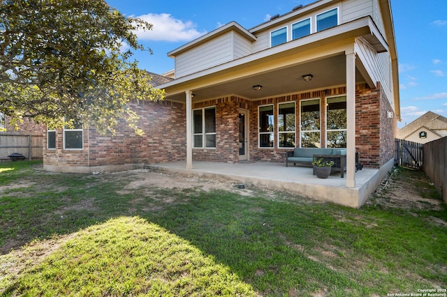 back of property with a patio area and a yard