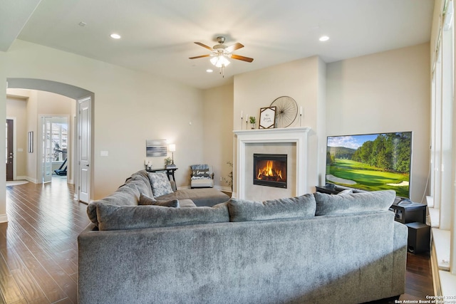 living room featuring ceiling fan and dark hardwood / wood-style floors