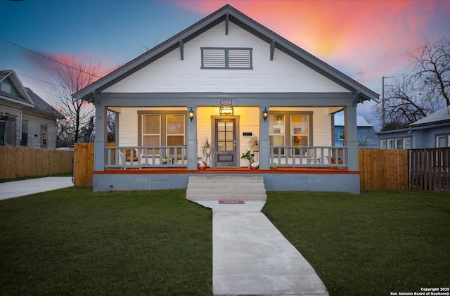 bungalow-style house with covered porch and a yard