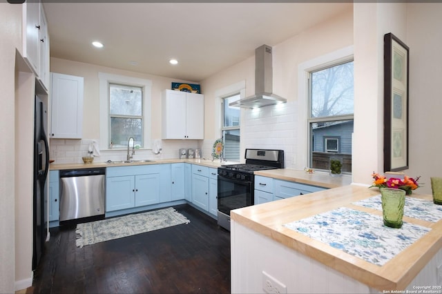 kitchen featuring stainless steel appliances, butcher block counters, island range hood, and white cabinets