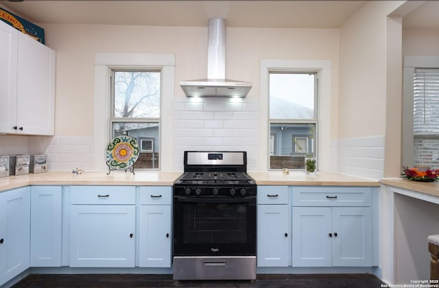 kitchen featuring island exhaust hood, gas stove, and white cabinets