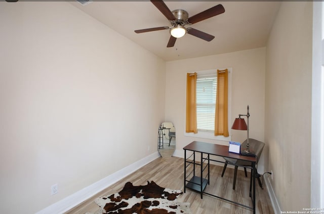 home office with ceiling fan and light hardwood / wood-style flooring