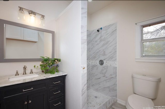 bathroom featuring tiled shower, vanity, and toilet