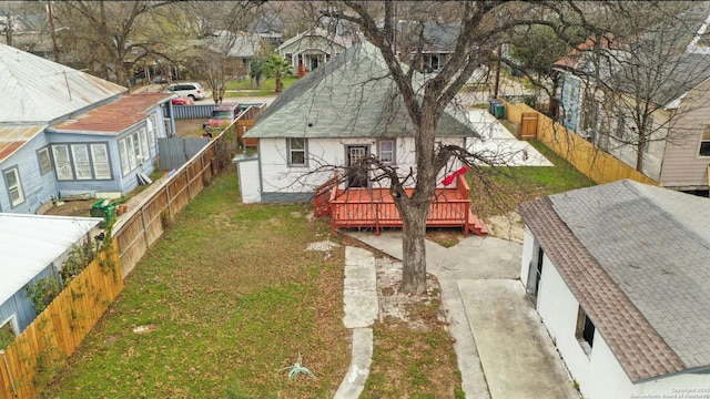 view of yard featuring a deck, a garage, and an outbuilding