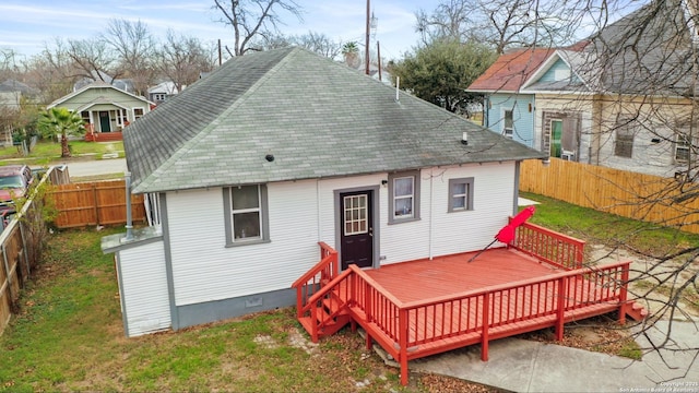 rear view of house featuring a deck and a lawn