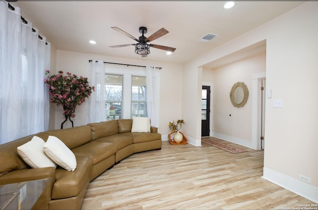 living room featuring ceiling fan and light hardwood / wood-style floors