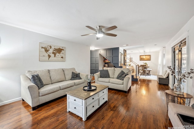 living room featuring ceiling fan and dark hardwood / wood-style floors