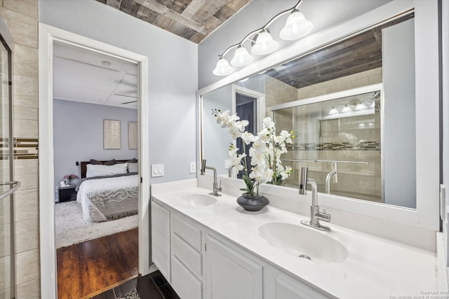 bathroom with wood-type flooring, an enclosed shower, and vanity