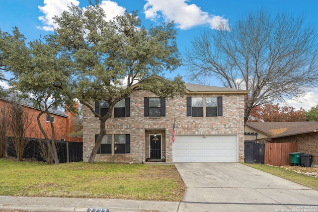 view of property featuring a garage and a front lawn