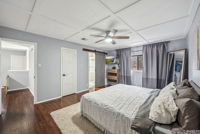 bedroom with dark wood-type flooring, ceiling fan, a barn door, and coffered ceiling