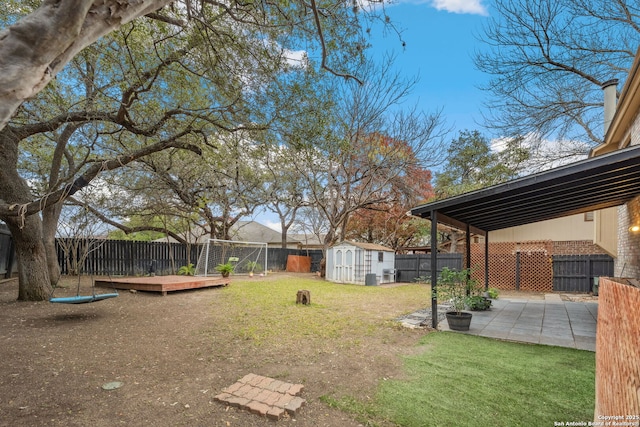 view of yard featuring a patio area, a wooden deck, and a storage shed