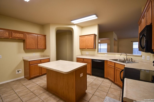 kitchen with black appliances, light tile patterned floors, sink, and a kitchen island