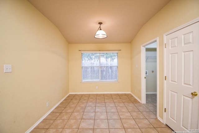 unfurnished dining area with light tile patterned floors and vaulted ceiling