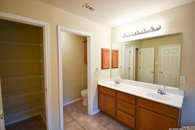 bathroom with toilet, tile patterned flooring, and vanity