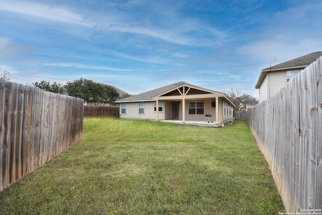 back of property with a patio area and a yard