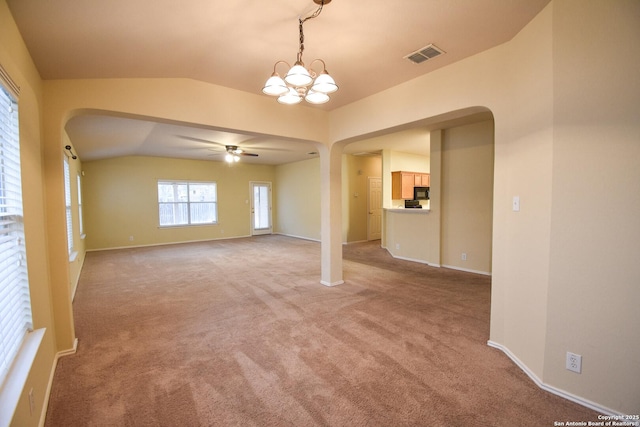 unfurnished room featuring ceiling fan with notable chandelier, light colored carpet, and vaulted ceiling