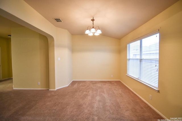 carpeted spare room with vaulted ceiling and a notable chandelier