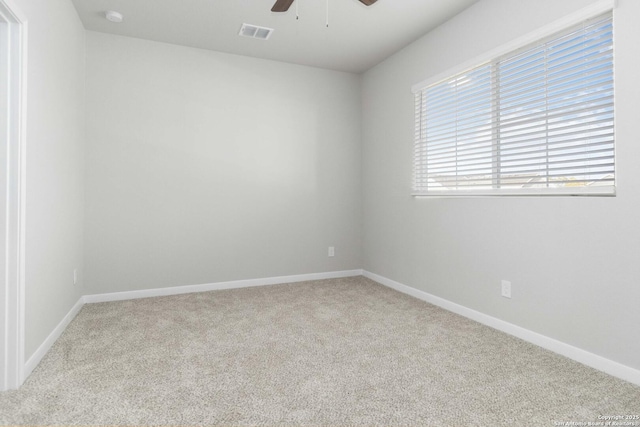 carpeted spare room featuring ceiling fan