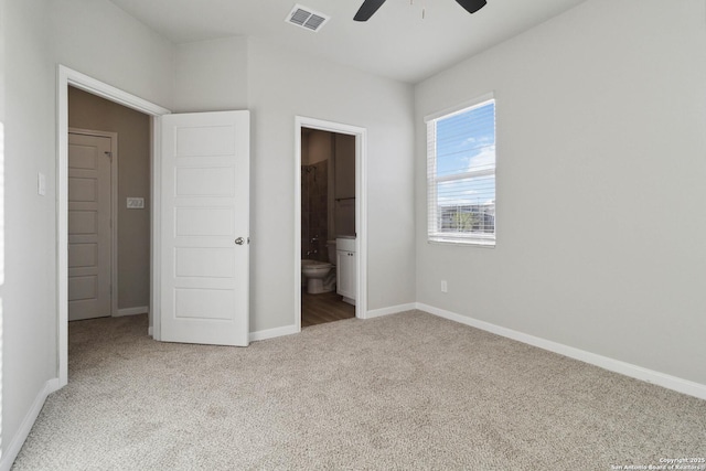 unfurnished bedroom with ceiling fan, light colored carpet, and connected bathroom