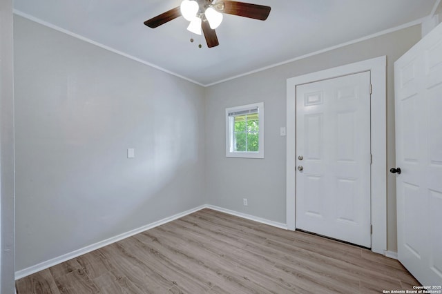 spare room featuring ceiling fan, crown molding, and light wood-type flooring