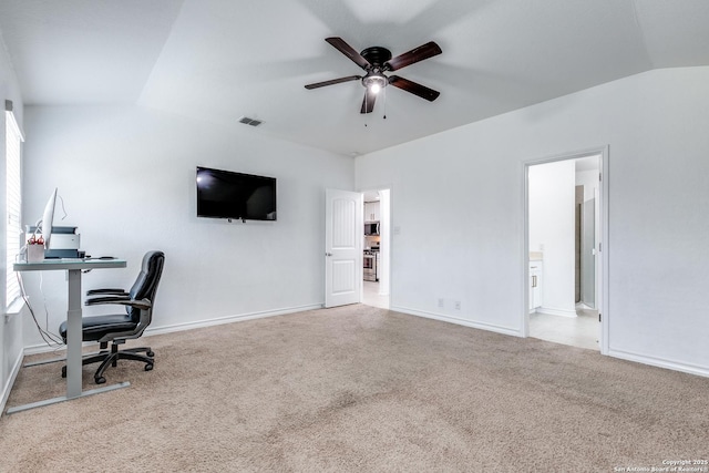 carpeted home office featuring lofted ceiling and ceiling fan