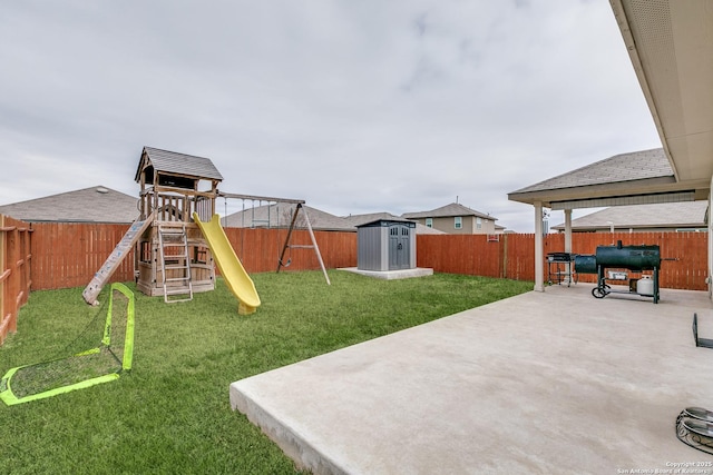 view of yard featuring a playground, a storage unit, and a patio