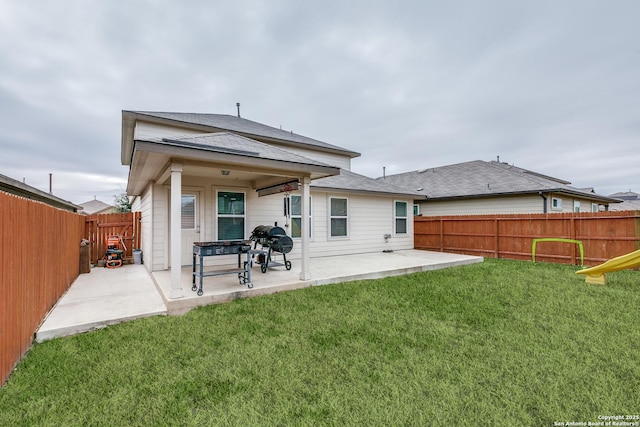 rear view of property featuring a yard and a patio