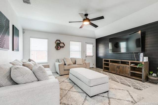 living room featuring ceiling fan and wooden walls