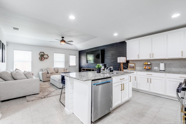 kitchen featuring white cabinets, a kitchen island with sink, light stone counters, and stainless steel appliances