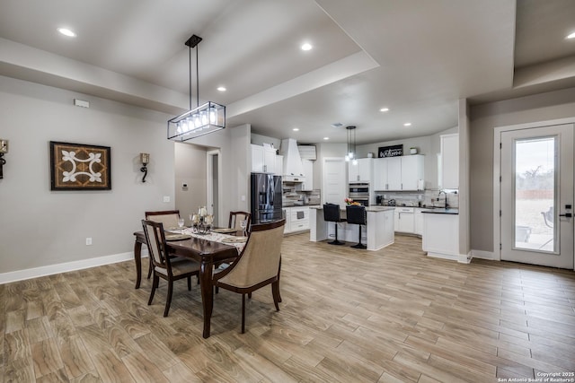 dining room with a raised ceiling and sink