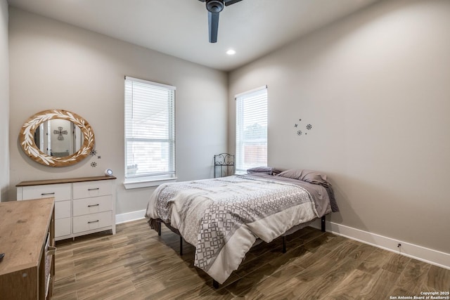 bedroom with ceiling fan, dark wood-type flooring, and multiple windows