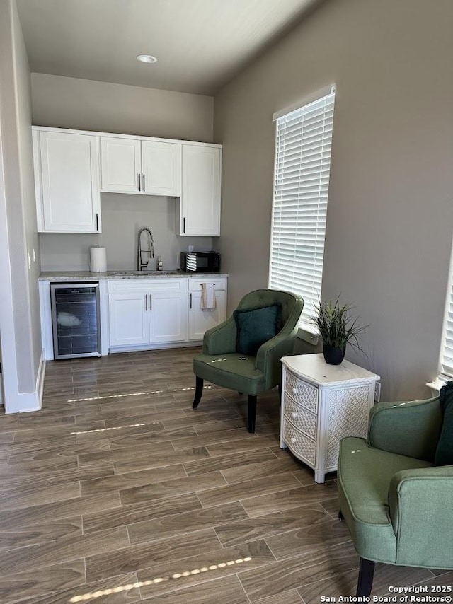 living area with beverage cooler and sink