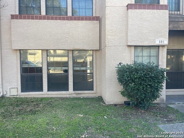 view of exterior entry featuring a yard